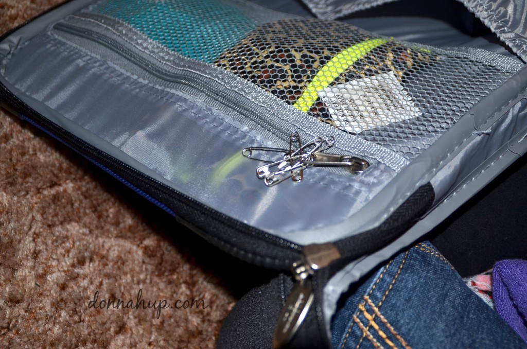 Safety pins clipped to zipper inside suitcase.